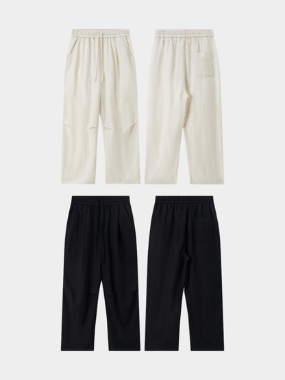 Black Mercer Society Drift Trousers shown flat, featuring a relaxed fit and stylish design for casual or smart casual wear.