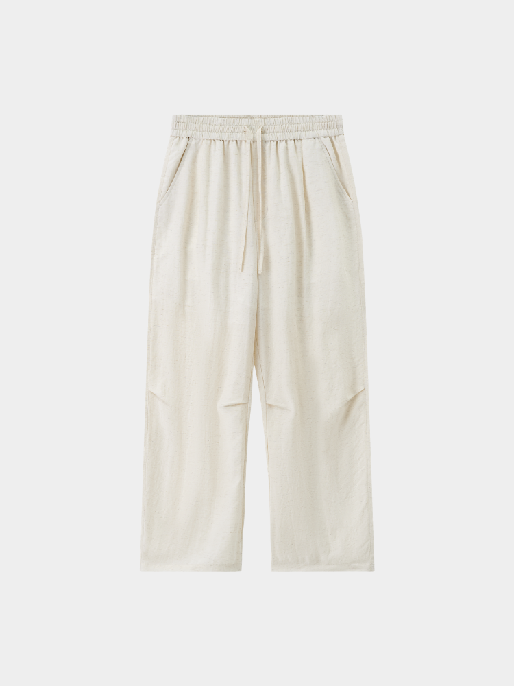 Ecru Mercer Society Drift Trousers shown on a model, relaxed fit with side pockets and tapered leg design.